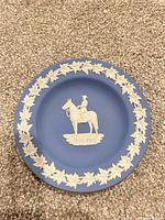 Front of blue jasperware dish showing mounted RCMP officer relief and maple leaf border