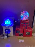 Crystal sphere lit multicolor on boxes; star globe lit blue on stand; three boxed crystal spheres visible