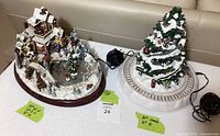 Both resin holiday pieces on table showing scale labels and power cords