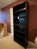 Full view of upright black-brown Billy bookcase showing shelves and finish