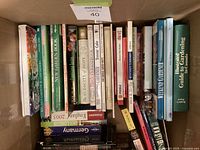 Box of assorted gardening, travel and other non-fiction books, spines visible