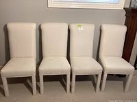 Front view of four matching off-white Parsons dining chairs lined up