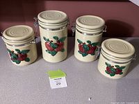 Front view of four ceramic apple motif canisters