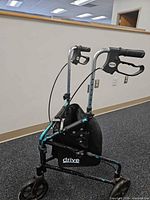 Left side view of Drive three-wheel rollator showing frame, wheels, brakes, pouch