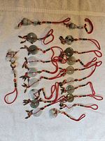All fifteen jade donut charms laid out showing cords, pendants and tassels