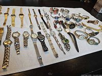 Full layout of assorted wrist watches on white towel