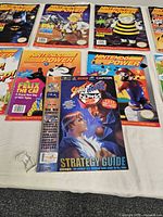 Nine Nintendo Power publications laid out; Street Fighter II guide on top