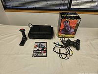 Overview of both PlayStation 2 consoles, joystick, controller, game case, cables and joystick box