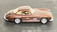 Left side view of metallic brown 1954 Mercedes-Benz 300 SL diecast