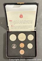 Open case showing all seven coins and certificate