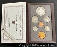 Open display case showing coins and certificate