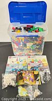 Overall lot showing tote filled with LEGO pieces, manuals and bagged parts