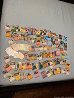 Wide view of full spread of Pokémon cards on a bed surface