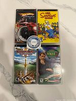 Front view of four PSP game cases and a loose Lords of Dogtown UMD disc