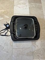 Top view showing grill with glass lid and power cord