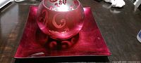 Etched red glass vase on matching red square plate