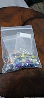 Zip-top bag containing assorted straight barbells with acrylic balls