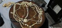 Overview of all gold-tone necklaces arranged on round table