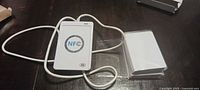 USB NFC card writer with attached cable and stack of blank NFC cards