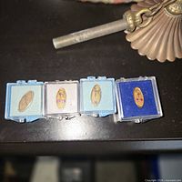 Four pins in presentation boxes on table