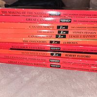 Stack of eight red-spined Canadian Centennial Library books with visible titles
