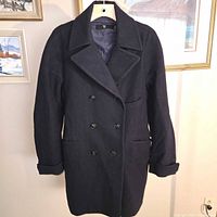 Front view of navy Uniqlo double-breasted wool blend coat on hanger