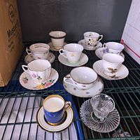 Shelf view showing all eight teacup and saucer sets
