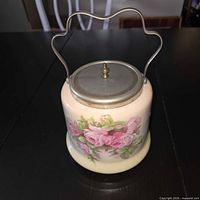 Front view of ceramic biscuit barrel showing floral design and handle