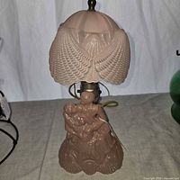 Full view of pink pressed glass lovers lamp with shade and finial