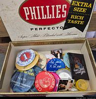 Open Phillies Perfecto cigar box filled with assorted vintage pinback buttons