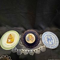 All three decorative plates on crochet doily