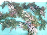 Both garland sections laid out showing greenery, silver leaves, berries and pine cones