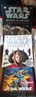 All three Star Wars books stacked: Revenge of the Sith Visual Dictionary, Episode I Visual Dictionary, Galaxy at War RPG