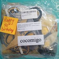 Bagged set of black and gold 40th birthday decorations with cocomigo label and Happy 40th birthday note