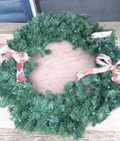 Full view of artificial Christmas wreath displaying greenery, ribbons, and overall form