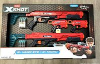 Front of sealed Zuru X-Shot box showing two Hawk Eye rifles, two Micro pistols, darts and can targets