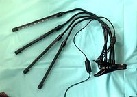 Four-head LED grow light with clamp and cable displayed on surface