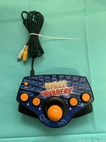 Top view of Space Invaders plug-and-play joystick console showing controls and attached RCA cable