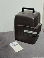 Projector closed inside brown plastic carrying case