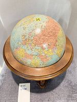 Full view of globe seated in wooden stand