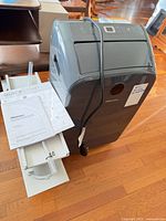 Portable air conditioner with window kit pieces, manuals, power cord