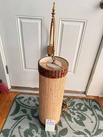 Full view of cylindrical swag lamp hanging from wall mount