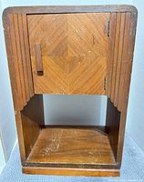 Front view of nightstand showing door, fluted accents, open shelf