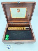 Open wooden box showing tiles, dice, felt base