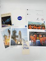 All items laid out: book, NASA folder, six photographs