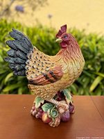 Front view of ceramic rooster figurine on fruit base