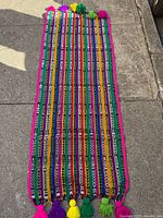 Full view of tzute laid flat showing entire length and tassels