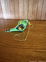 full view of green ceramic bird figurine with hanging cord