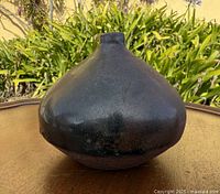 front view of round dark-glazed stoneware vase