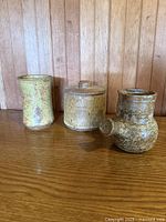 All three stoneware pieces side by side on wooden surface